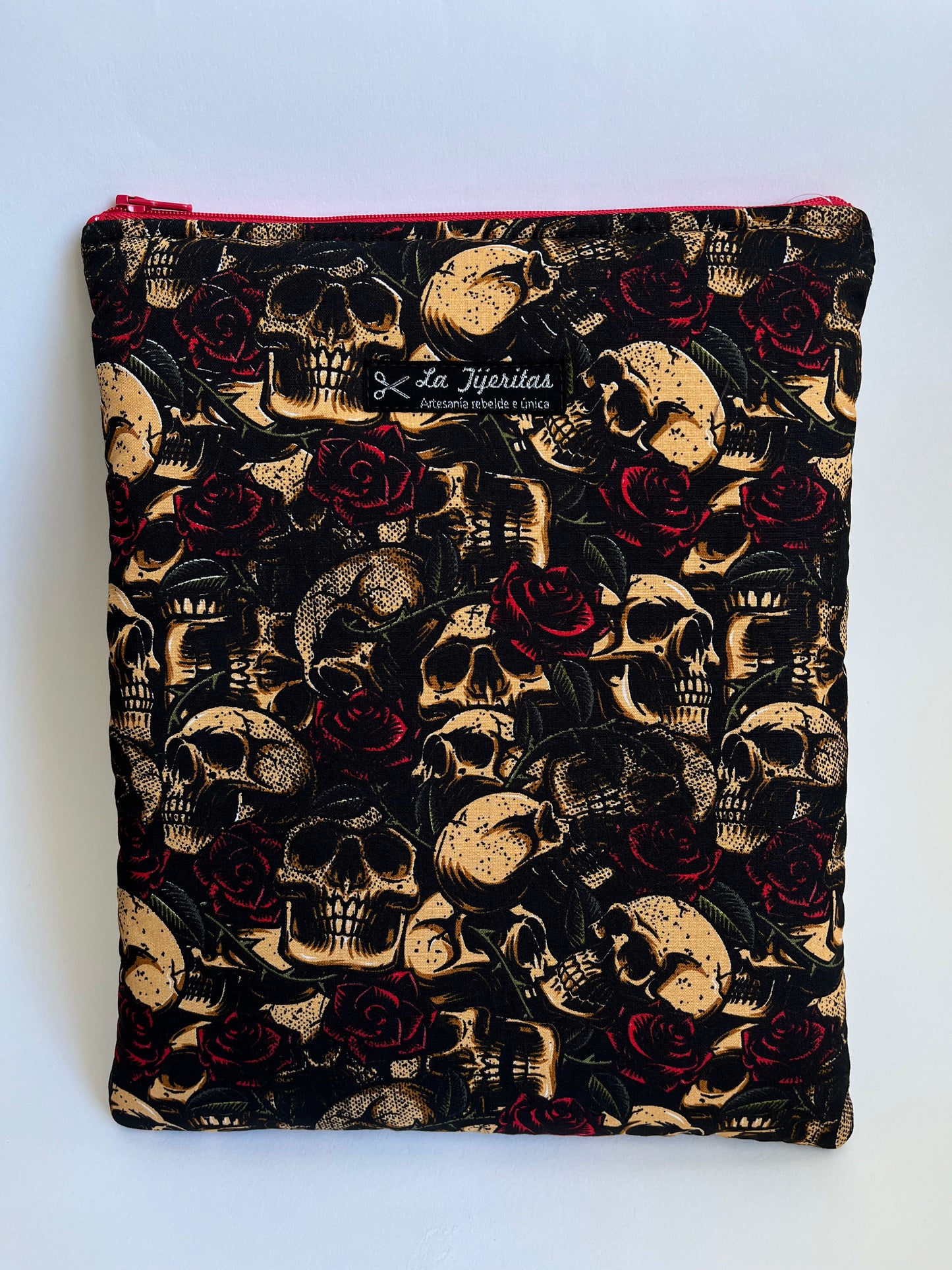 Funda de libro de color negro con calaveras beige y rosas rojo oscuro. Tiene tiras a contraste de color vino.