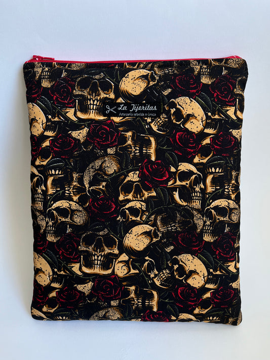 Funda de libro de color negro con calaveras beige y rosas rojo oscuro. Tiene tiras a contraste de color vino.